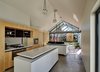 The kitchen features a white stone countertop from Stone Italiana and Hoop Pine plywood cabinets. The cooktop is Bosch, the oven is from Ariston, and the refrigerator is Samsung. Photo 6 of Cut Cut Paw Paw modern home