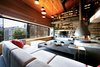 Modern home with Living Room, Hanging Fireplace, Sectional, Coffee Tables, and Pendant Lighting. The team’s design philosophy was “not to have too many ideas,” and instead focus on a few key aesthetic moves that would be carried through the entire space. The lower living level features a full-wall storage system and statement hearth on a concrete platform. Sectional seating offers sweeping city views of Karakoy, including an old Armenian church and Galata Tower. Photo of A Single-Room Loft with Impressive Wall-to-Wall Storage