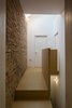 A spare material palette characterizes the interiors, with brick walls left exposed wherever possible to showcase the home's history. Photo of An Award-Winning London Addition Balances New and Old modern home