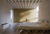 Structural lines are on full display in the bedroom, where ceiling beams and a plywood bed frame catch the eye. Photo of An Award-Winning London Addition Balances New and Old modern home