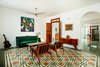 Eye-catching patterned tile offers a bold focal point in the living room. Antique midcentury chairs and a credenza furnish the space. In the living room and beyond, the architects purposefully avoided an open floor plan in favor of a collection of traditionally defined spaces. “Every space has its own character and belongs to a whole simultaneously,” says project architect Atahualpa Hernandez Salazar. Photo 2 of Casa Mérida modern home
