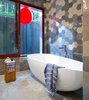 Modern home with Bath Room, Freestanding Tub, Concrete Floor, and Ceramic Tile Wall. The master bathroom’s Aquabrass tub is next to a window lined by fumed oak millwork framing a tethered red balloon, displayed for levity. Photo of 50+ Modern Tile Ideas for Walls, Floors and Ceilings
