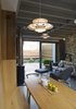 Multiple skylights, including one over the kitchen, bring sunshine into the home while keeping it private from surrounding neighbors. Pendant lights by Arne Jacobsen for Louis Poulsen, hanging over a dining table by ercol furniture, provides additional illumination. “The kitchen-dining-living room is cozy, but it is large enough to entertain 12 people,” Thomson says. The green chair is a prototype from Barber Osgerby and the rug is by Kate Blee. Photo 3 of Islington Residence modern home