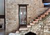 Modern home with Staircase and Metal Tread. Biophilic design prefers natural over synthetic materials, as human beings innately feel more at ease with the former. In this house in Israel, the limestone walls are recycled from dismantled houses in the region. The stone staircase is original. Photo of A 250-Year-Old Stone House in Israel with a Surprisingly Modern Interior