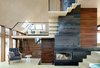 Modern home with Living Room, Table, Chair, Concrete Floor, and Corner Fireplace. A central wood-burning fireplace efficiently heats the whole home, minimizing the need for supplemental in-floor heating incorporated in the concrete floors. Natural cross-ventilation is achieved through the use of CO2 directed grills at the north and south of the home, an added green feature that further reduces the ecological footprint. Photo 5 of Dune House