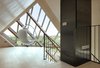 The top floor of the home offers striking views of the surrounding dunes and North Sea. Simply accented with a suspended bubble chair by Aarnio Eero, the viewing platform is the owners’ favorite part of the home. Photo 7 of Dune House modern home