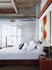 Modern home with Bedroom and Bed. Like the communal spaces, the bedroom features a shining subway tile wall. Photo of Raw Materials Connect this Chicago Renovation with its Industrial Past