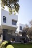 The home's materials are organized vertically: white exteriors towards the lighter sky, dark recinto stone close the earth and the foundations, and a moderating concrete in between. Photo of A Daring Hillside Home Made of Wood, Concrete, and Volcanic Stone modern home