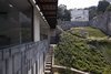 The architects designed a picturesque texture for the hillside that provides a stimulating visual landscape. The recinto stone—seen left—is rhythmically divided by small ridges that also mark the passage of time with their shadows. Photo of A Daring Hillside Home Made of Wood, Concrete, and Volcanic Stone modern home