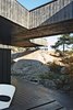 Modern home with Outdoor, Boulders, Large Patio, Porch, Deck, Wood Patio, Porch, Deck, and Trees. A section of the roof reaches over a rock outcropping—a detail that visually connects the house to the landscape and offers a handy way to climb up to the roof deck without using a ladder. Photo 6 of 430 Cabin