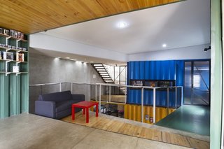 Natural light pours into the open-plan house, which is outfitted with low-cost materials like polished concrete floors and recycled metal railings.