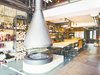 Modern home with Living Room, Gas Burning Fireplace, and Hanging Fireplace. A cast-in-place concrete kitchen island features a cantilevered concrete dining table. The hearth’s plinth offers added seating at the table during crowded gatherings. Photo of A Single-Room Loft with Impressive Wall-to-Wall Storage