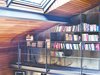 One entire wall of the space is dedicated to storage. A simple, clean iron rod shelving system was conceptualized to span the entire wall left to right, and both floors top to bottom. Depending on the location of the storage wall, the nondescript iron grid can be used to house items in the living room, kitchen, library, or bedroom areas. Photo of A Single-Room Loft with Impressive Wall-to-Wall Storage modern home