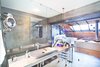 Modern home with Bath Room and Vessel Sink. The main bathroom is only partially separated from the sleeping area by a glass partition. The absence of opaque walls creates a feeling of openness and cohesion in the bright mezzanine space. Photo of A Single-Room Loft with Impressive Wall-to-Wall Storage