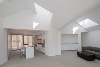 Sunlight permeates the interior thanks to skylights within the thermal chimneys. A single common area, comprising a kitchen, dining, and living area, links all the three bedrooms.