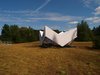 Made with a sensitivity to its site, the white, faceted structure pops out against a sylvan landscape of grass and greenery further afield. The elevated edges seek to reduce the amount of points touching upon the biotope meadow. Photo of A Modular, Translucent Pavilion With a Fabric Facade modern home