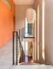Modern home with Staircase, Wood Tread, and Metal Railing. A Cascade suspension light by Ango hangs over the stairway. Extra-thick, exposed concrete floors contribute to the home’s radiant heating and cooling system. “There’s more upfront cost, but because Jackson’s heating season is so long, it’s actually a very economical choice,” Logan says. Photo of A Fun, Cost-Conscious Home with Bright Interiors and a Climbing Wall