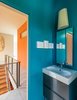 Modern home with Bath Room and Drop In Sink. A Kite wall sconce by Foscarini and mirrors from Gedy by Nameeks are installed above a polished chrome faucet from Kohler’s Purist collection. Photo of A Fun, Cost-Conscious Home with Bright Interiors and a Climbing Wall