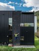 Modern home with Exterior, House, Metal Siding Material, and Flat RoofLine. Dotted with colorful footholds, a climbing wall covers one side of the home, allowing roof access. Photo of A Fun, Cost-Conscious Home with Bright Interiors and a Climbing Wall