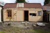 The original rear façade can be seen, in stark contrast to the modern update. Agata and Chris Millington, an internal space planner and builder/developer, were eager to put their creative stamp on the home. Chris acted as project manager for the renovation, and the couple worked diligently with the architects to ensure the project was completed on time and under budget. Photo 2 of 1850s Prefab Cottage from Boston Finds New Life in Australia modern home