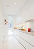 Modern home with Kitchen. The galley kitchen, in classic white, is the one splurge within the interior: it was custom made by Bulthaup from their B1 series. A narrow window, with a frosted bottom panel, balances views and privacy. Photo of Designing for Privacy: 14 Discreet Uses For Frosted Glass