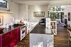 This house in Carmel by the Sea is enlivened by its very red kitchen cabinetry. By knocking down a dividing wall, the architects opened the kitchen up to the rest of the living space. Ikea red lacquer cabinetry and Caesarstone countertops replace dingy cupboards and old-fashioned finishes. Stainless steel appliances help ground the airy, open space. Photo 6 of Torres House modern home