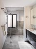 On the house’s lower level, Schicketanz’s guests have a bathroom complete with a steam shower to themselves. Anodized aluminum windows pop against white subway tile from Waterworks. The vanity is from Ikea and the fixtures from Hansgrohe. Photo 9 of Torres House modern home