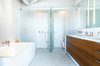 “The structural elements were left rough and exposed while the baths were designed to be clean and sleek,” Severns says. The bathroom is by Henrybuilt. Photo 4 of Parker Willis House modern home