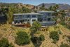 Other than maintaing the original footprint, Johns completely transformed the residence, increasing the height of the rooms and adding a family room and 2,200 square feet of deck space. Johns aimed to use materials that would age well—the structure was built with cement stucco and poured-in-place concrete, and features double-glazed aluminum windows and doors. Photo of House in the Los Angeles Hills Inspired by California Modernists modern home