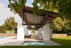 White-painted brick piers support the structure, which is designed to mimic design elements of the original 1930s farmhouse, approximately 100 yards away. Photo of Striking Pool and Guest House in Virginia modern home
