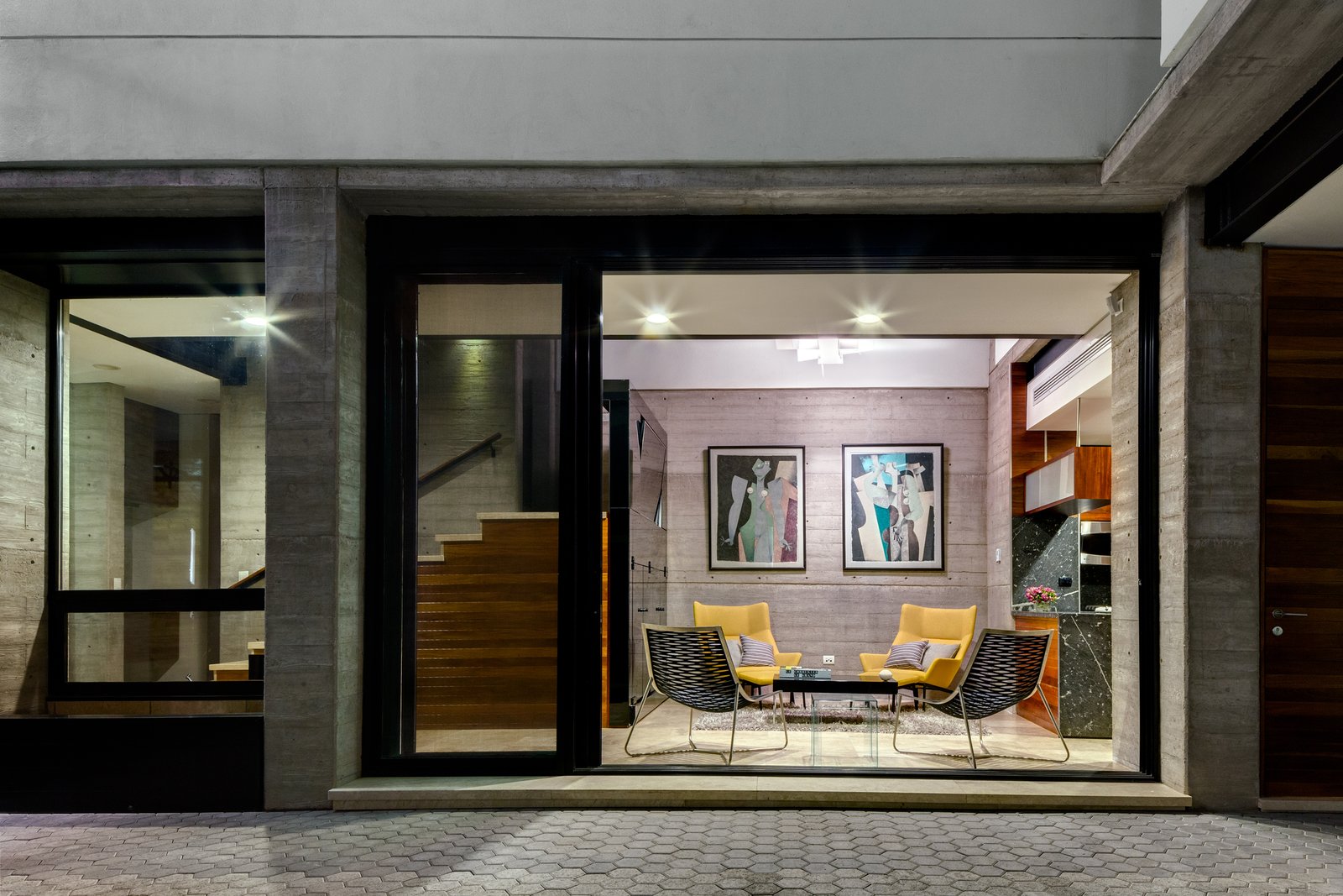 The home’s living room connects to the patio through sliding glass doors. Both social spaces, the living room and kitchen, have double high ceilings. These areas are divided by the granite kitchen bar, and are unified by the open patio.