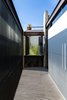 New balconies were constructed to complement the scale of the adjacent openings. The second story balcony was conceptualized as an extension of the room to the street. It can be closed when privacy is required, but opened to the street or terrace for interaction with the natural surroundings. The metallic blinds create dynamic shadow patterns as the light changes throughout the day. Photo 6 of Hybrid Home modern home