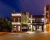 The front elevation is seen at night. The old structure fits on a compact 130-square-foot lot, while the new building adds an extra 1,000 square feet. Adobe walls, wood beams, limestone facade, and earthen roof all make up the tactful blend of old and new. Photo 10 of Hybrid Home modern home