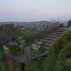 Previously “leftover” space, a secluded deck featuring two green Loll chairs offers stunning views of downtown. Photo of A Spa-Like Patio with Stunning Views Cascades Down a Los Angeles Hillside modern home