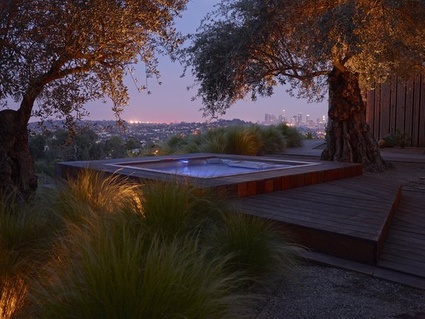 Three olive trees currently anchor the hot tub and deck area. The architects explain that transplanting them with a crane essentially positioned on a cliff face was one of the biggest challenges of the project.
