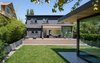 Modern home with Outdoor, Back Yard, Grass, and Wood Patio, Porch, Deck. The landscaped backyard acts as a second, open-air living space between the home and garage studio. The cladding on the addition is painted in Benjamin Moore’s Iron Mountain, and the deck is stained western red cedar. Photo 15 of Trotman Residence