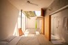 The airy bedroom also features concrete floors and pine accents, including a traditional Mexican chair. Reflecting white tiles are used in the adjoining shower, and a hammock hangs in the background. Photo of This Super Green Home in Mexico Embraces Nature Through Huge Pivoting Glass Doors modern home