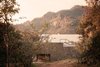 The home is seen in the context of the natural surroundings, with the iconic Tepozteco mountain in the background. By continuously opening to the outdoors and favoring materials that will age gracefully, the home forms a dynamic, symbiotic bond with nature. Photo of This Super Green Home in Mexico Embraces Nature Through Huge Pivoting Glass Doors modern home