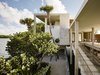 The landscape was designed by Raymond Jungles to be "cultivated wild" with native trees and grasses amid a bed of oolite stone. Photo 3 of Casa Bahia modern home