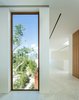 Hurricane-proof windows by Peetz frame the lush landscape. The floors are made from Spanish macael marble, and the walls feature hand-applied matte Italian microplaster designed to mirror the appearance of clouds. Photo 6 of Casa Bahia modern home