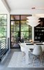 Modern home with Dining Room, Table, Chair, Pendant Lighting, Rug Floor, and Shelves. In the dining area are a Gamma table by Cappellini, Eames molded plastic chairs, and a Flotation pendant by Ingo Maurer. Photo of Eames Molded Chairs