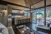 Brilliantly designed by architect James E. Norman, this home is striking and one-of-a-kind. The rock wood-burning fireplace, curved rock wall entrance and exposed post and beam construction all lend themselves to defining this mid-century modern's wholly unique style. Photo of Unforgettable Midcentury Homes by Modern Masters modern home