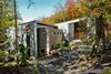 Modern home with Outdoor, Trees, Hardscapes, Gardens, Walkways, Front Yard, and Woodland. “The site was beautiful as it is,” architect Eric Tremblay said, and he wanted to build a home that had the least impact on the terrain as possible. The lake can be seen on either side of the house, and natural materials—like the Eramosa limestone coating on the exterior—were a priority during construction. Photo of Chalet Lac Gate