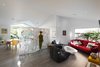 Previously a much darker space framed by a low ceiling, the living room now features large glass panels that draw residents outside and admit bountiful natural light. The sofa is by Ligne Roset. Photo of A California Cottage Renovated for Easy Indoor-Outdoor Living modern home