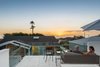 What this cottage lacks in size is made up for by stunning views of the ocean. The homeowners lounge on a Crate & Barrel sofa underneath a Hausers umbrella. Photo of A California Cottage Renovated for Easy Indoor-Outdoor Living modern home