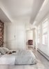Modern home with Bedroom, Bed, and Light Hardwood Floor. The renovation revealed a 30-foot-deep well beneath the bedroom, which the team half-jokingly considered turning into a fish tank. Instead, they opted for a simple bedroom with plenty of built-in storage. Photo 3 of Beacon Hill