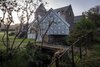 Modern home with Exterior, House Building Type, Metal Roof Material, Metal Siding Material, and Shingles Roof Material. While making its own unique mark, the studio is also deeply respectful towards its historic surroundings. The structure sits directly on top of a Victorian "midden wall," an enclosure traditionally used by the adjacent stables as a depository for horse manure. The studio's twin gables mimic its direct neighbors, and the zinc molding on the gutter also echoes its Victorian predecessors. Photo 7 of Midden Studio