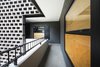 Modern home with Hallway and Concrete Floor. Little remains of the former hotel except for the motel-style exterior corridors, which combine a concrete-brick lattice and plywood details. Photo 4 of Hotel Carlota