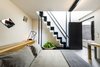Modern home with Bedroom, Concrete Floor, Bed, and Table Lighting. Each room was designed by a group of young interior designers and features details like custom wood installations, concrete furniture, rugs by Lagos del Mundo, and works by contemporary artists curated by Arróniz Galería. The black stairs lead up to a private roof deck perfect for sunbathing and enjoying views of the city rising around the hotel. Photo 5 of Hotel Carlota