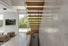 Inside, the home immediately opens up with light and natural views. The cantilevered stairs leading to the first floor offer a dramatic focal point. The stairs, wrapped in natural oak, are anchored to the exposed concrete walls on one side, and bordered by a clear glass railing on the opposite side. Photo 2 of Rishon Le Zion 3 modern home